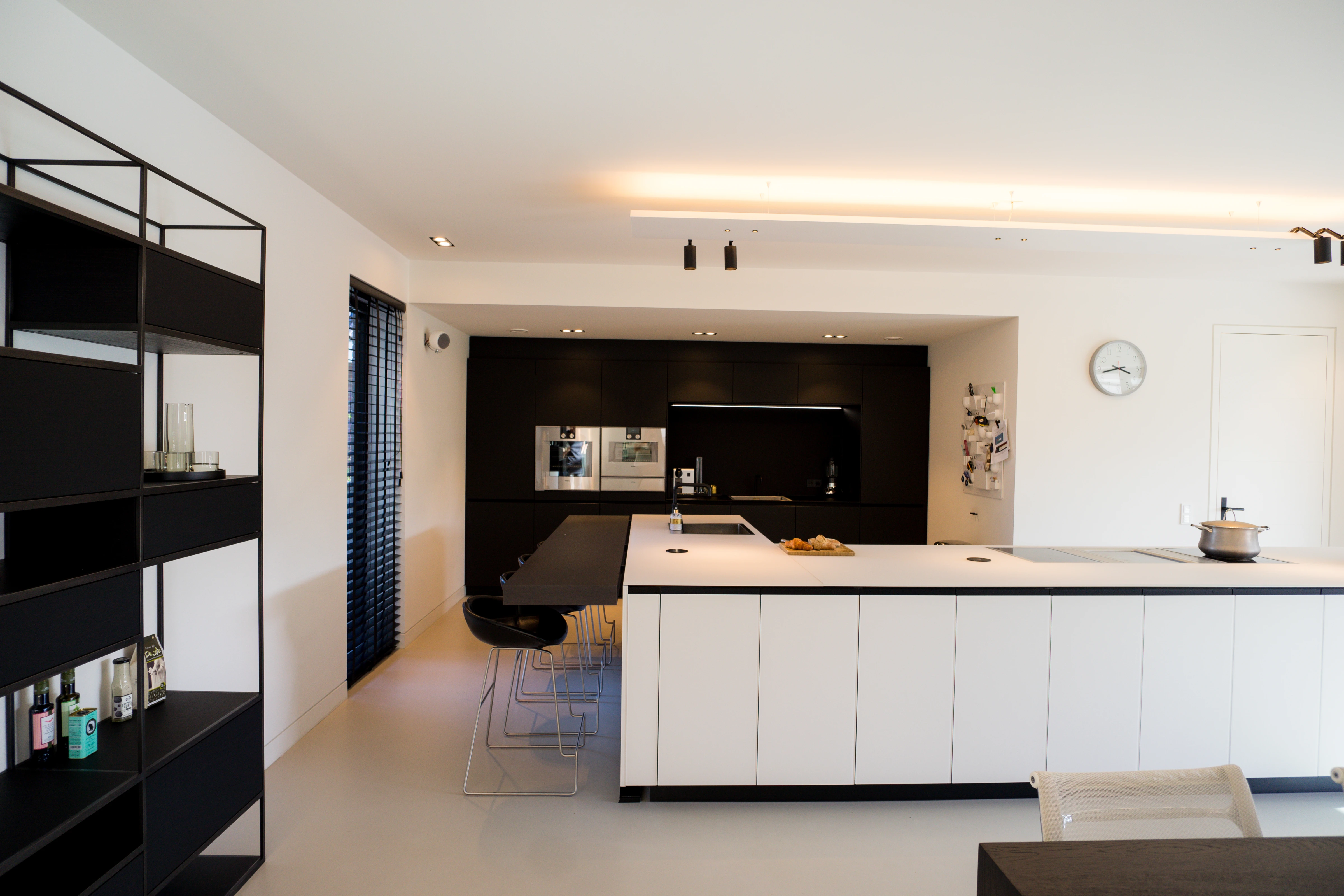 Keuken en kastenwand met een zwart stalen open kast op de voorgrond