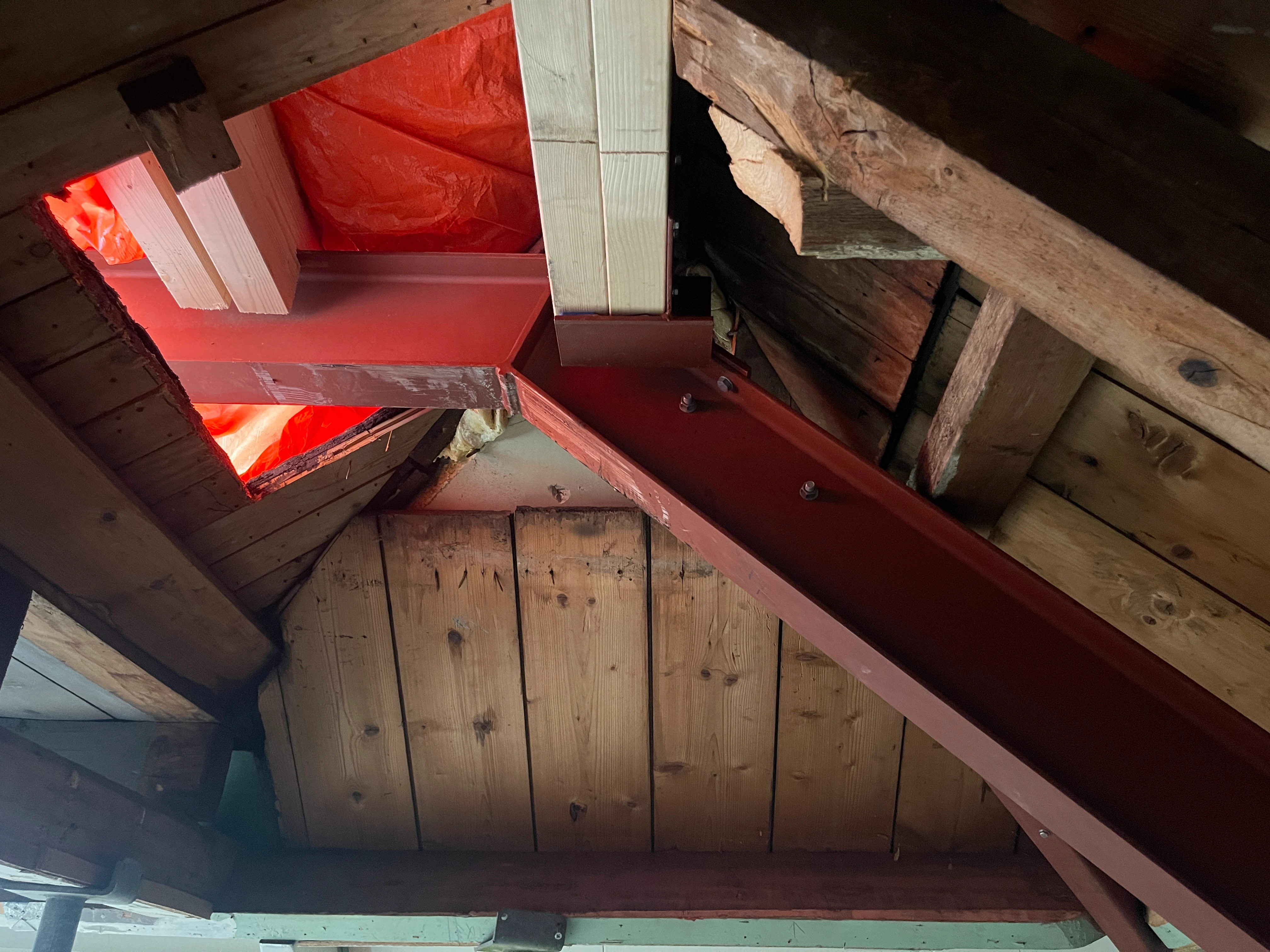 Nieuwe stalen liggers en houten spanten tussen de oude kapconstructie op zolder