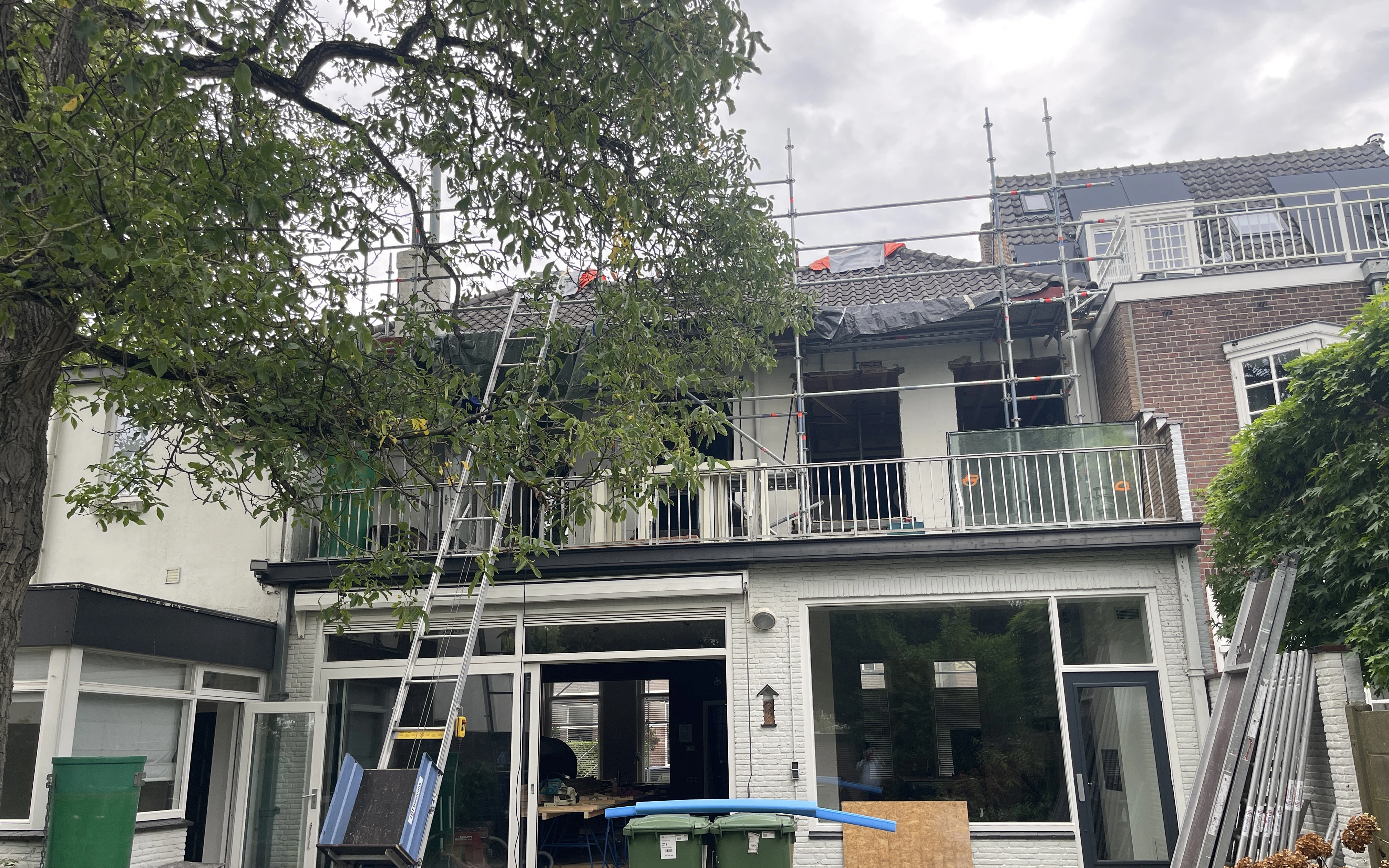 Achtergevel van de woning in de steigers, met open kozijnen en een dak dat is opengelegd
