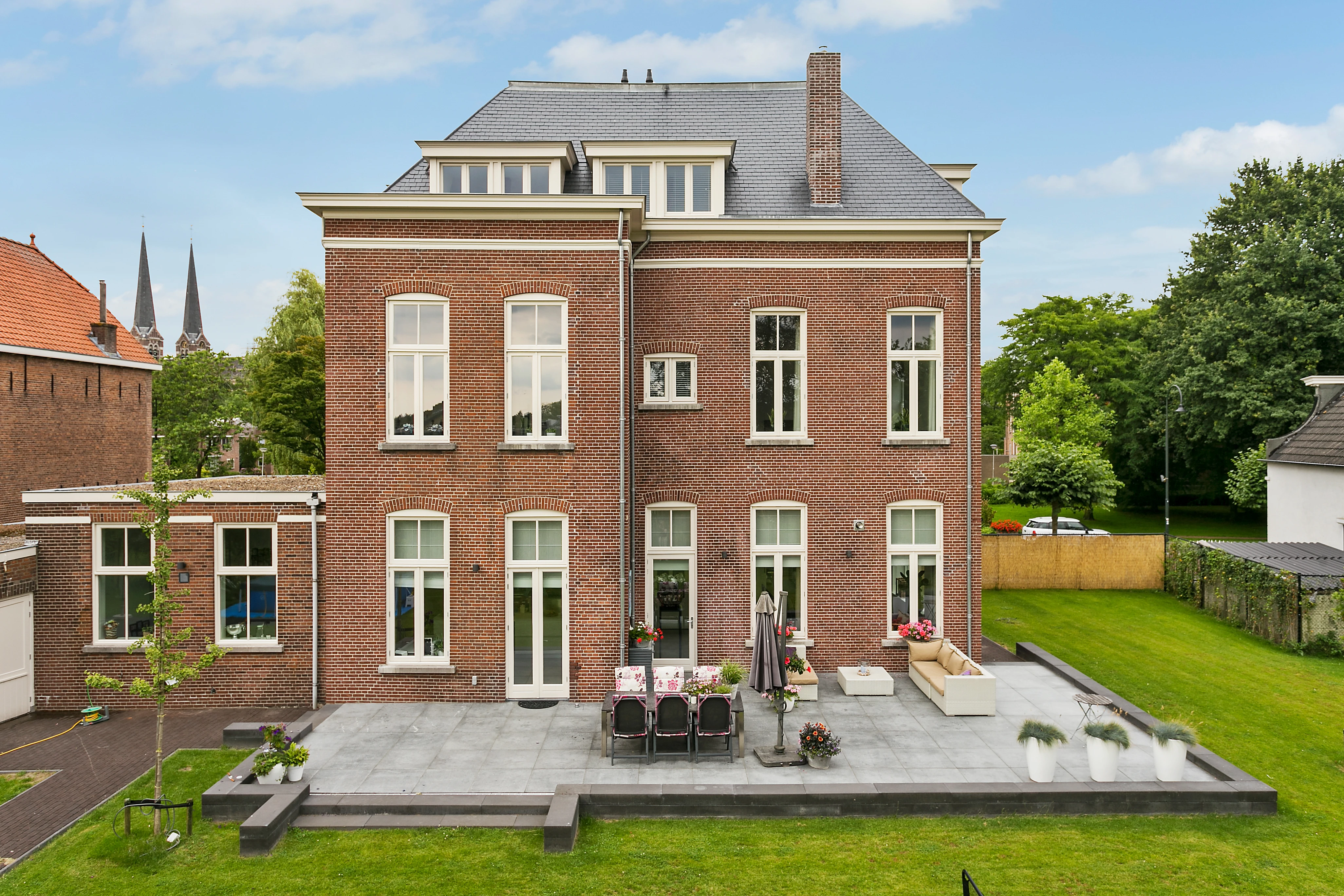 Voorgevel van het monumentale pand met torentje en erker, gezien vanaf de straat