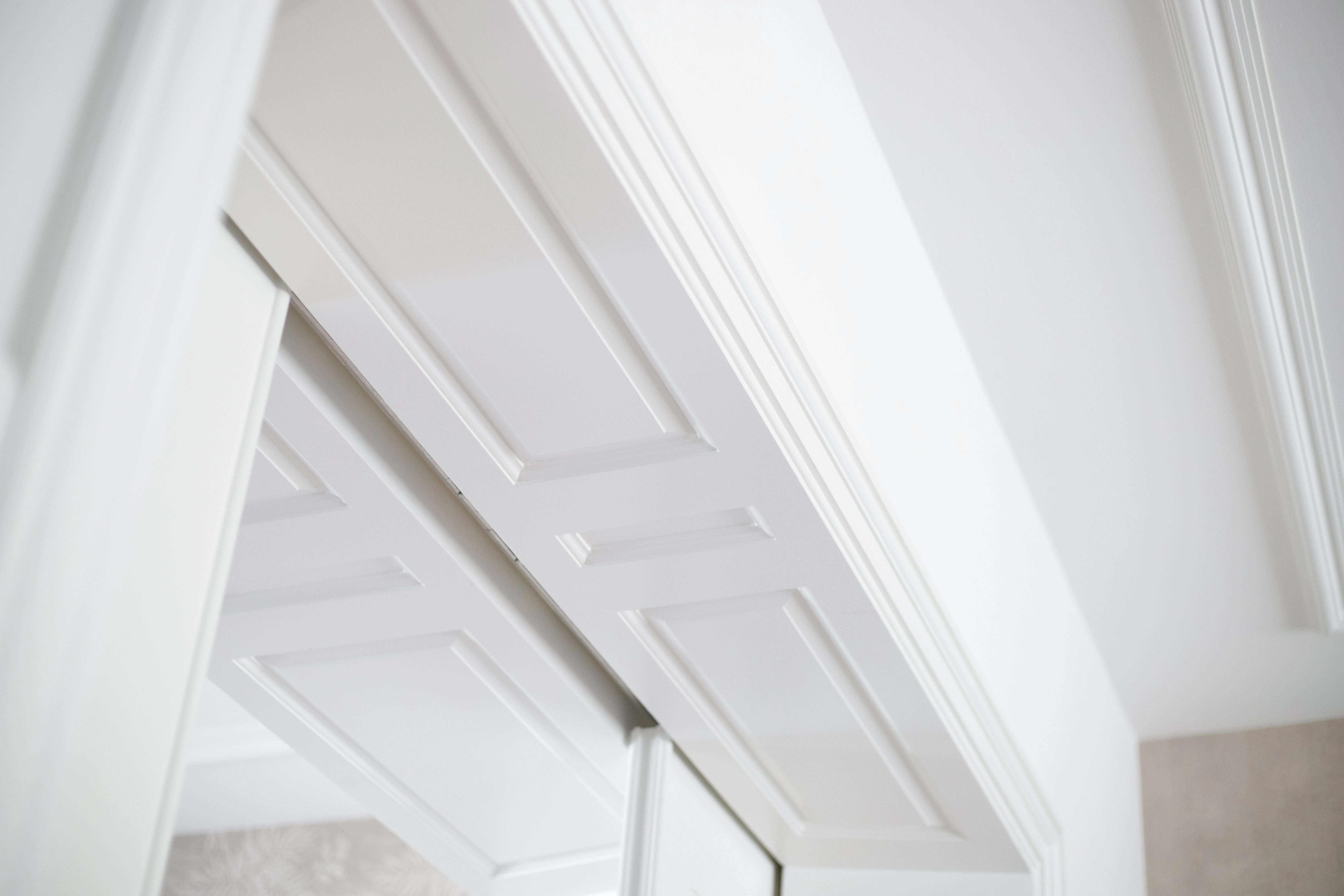 Detail van een wit paneeldeurkozijn met kroonlijst