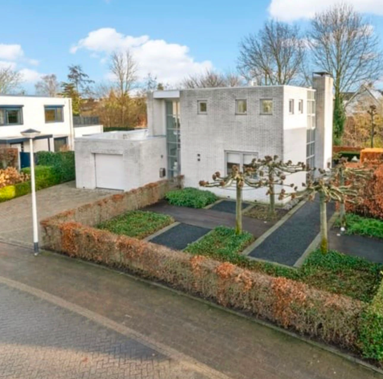 De woning vóór de aankoop, gezien vanaf de straat met een aangelegde voortuin